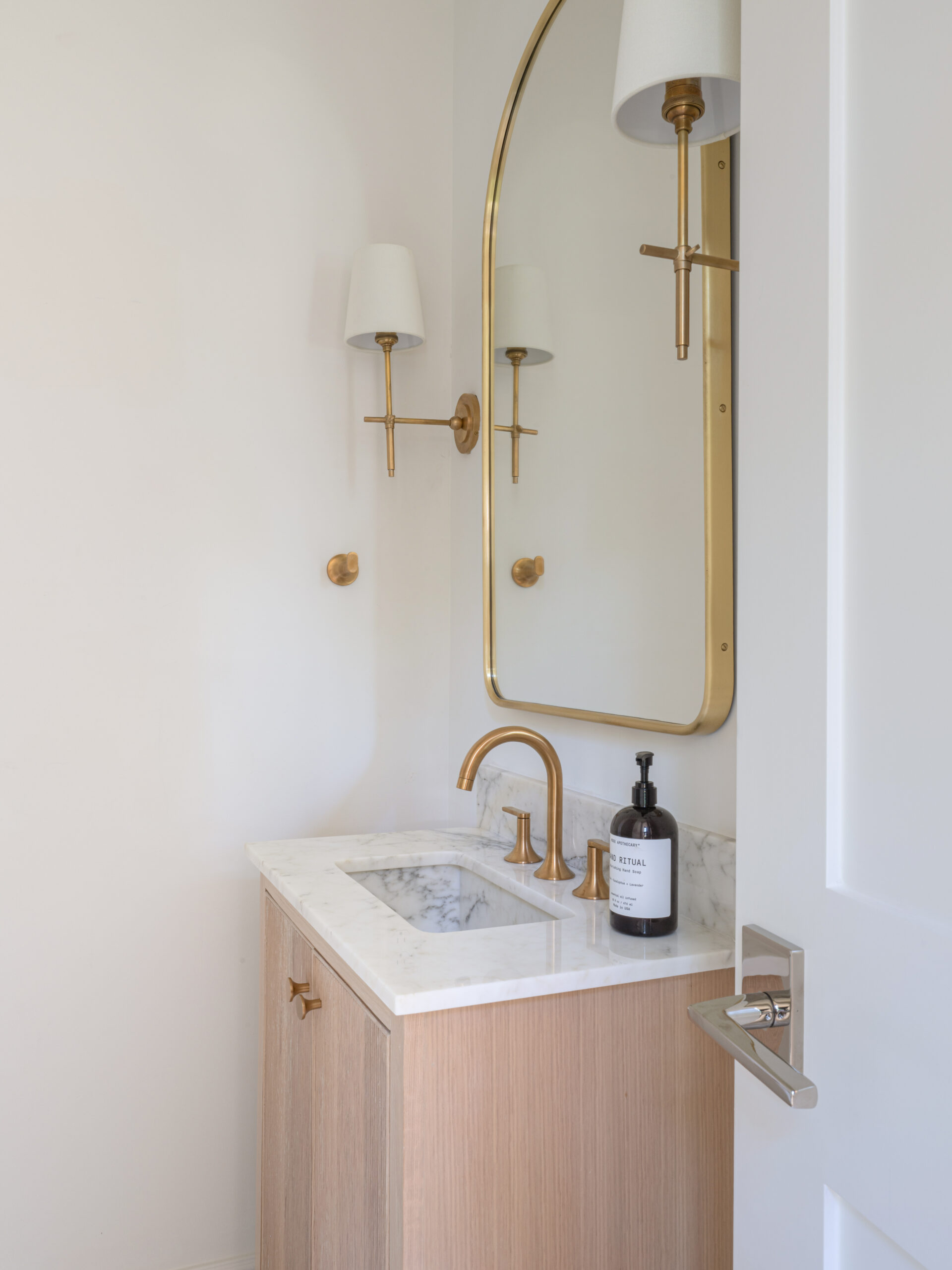 CLASSIC EUROPEAN REVIVAL – Chamberlain Arlington Heights, Lafayette Ave, Fort Worth, TX 76107-38 Powder bath with arched brass mirror, brass faucet, and oak vanity — Blue Cypress Design Build, Fort Worth TX