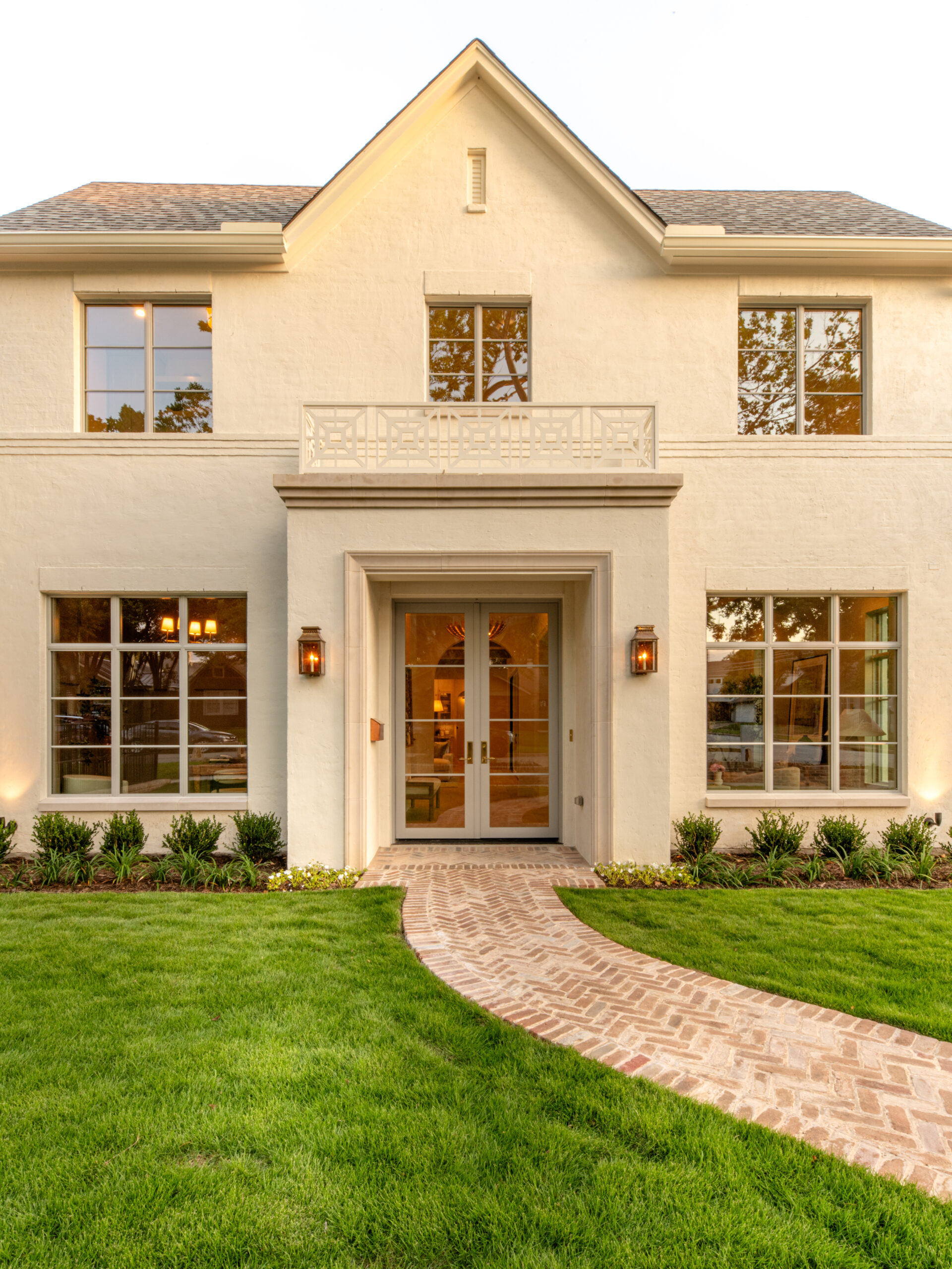 CLASSIC EUROPEAN REVIVAL – Chamberlain Arlington Heights, Lafayette Ave, Fort Worth, TX 76107-47 Classic European Revival facade at dusk with balcony and brick path — Blue Cypress Design Build, Fort Worth TX