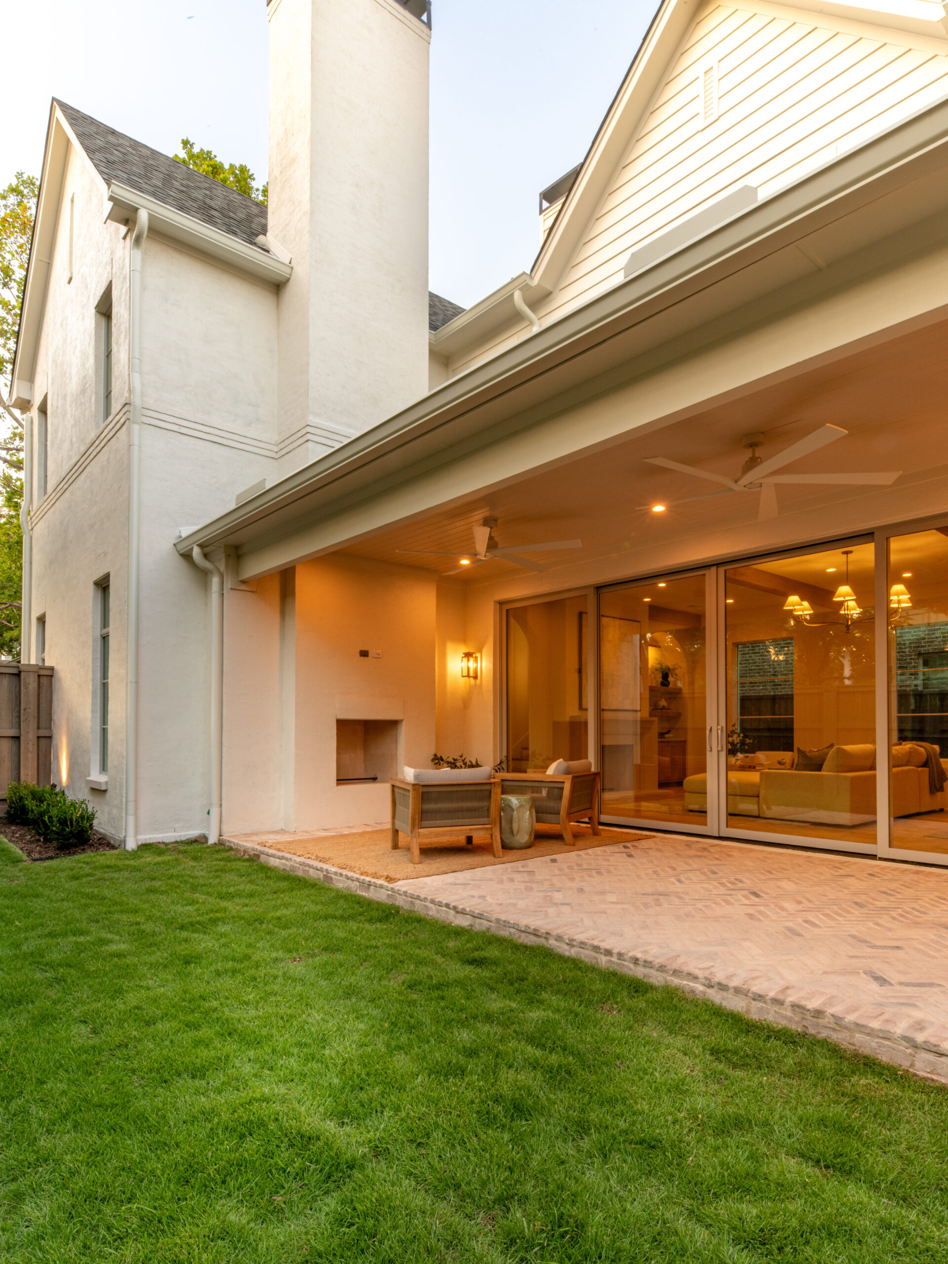 CLASSIC EUROPEAN REVIVAL – Chamberlain Arlington Heights, Lafayette Ave, Fort Worth, TX 76107-50 Covered patio at dusk with outdoor fireplace and sliding glass wall — luxury custom remodel, Fort Worth TX